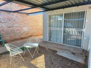 two chairs and a table on a patio at LaBoezma Accommodation in Oudtshoorn