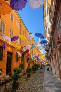 a street with many umbrellas hanging from buildings at appartamento Pekoe in Modena