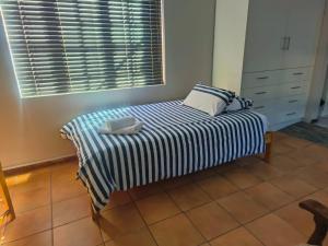 a small bed in a room with a window at LaBoezma Accommodation in Oudtshoorn