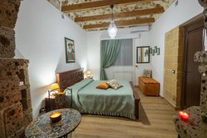 a bedroom with a bed and a table in a room at Tri Re e 'na Regina in Cinisi