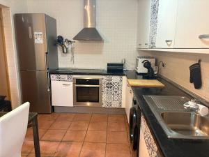 a kitchen with a sink and a refrigerator at Casa Rural Aires de Mondalindo in Bustarviejo