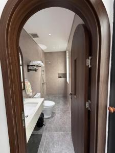 a bathroom with a sink and a toilet and an open door at MoonLight Homestay in Hòa Bình