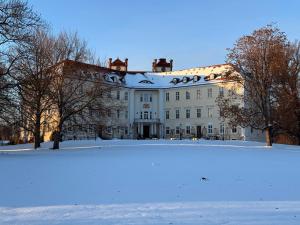 a large white building with snow on the ground at Ferienwohnung an der Postsäule Lübbenau in Lübbenau