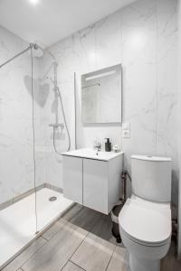a white bathroom with a toilet and a shower at Sweet-patio in Briey