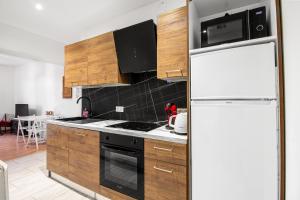 a kitchen with wooden cabinets and a white refrigerator at Sweet-patio in Briey