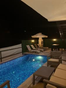 a swimming pool with lounge chairs and an umbrella at Villa Nazard in Kaş
