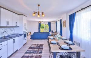 a kitchen and living room with a table with chairs at Villa Nazard in Kaş