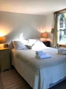 a bedroom with a bed with two towels on it at Shackmatack in Tenants Harbor