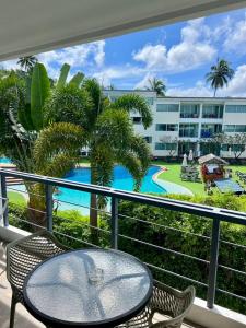 a balcony with a table and chairs and a pool at The nice condo 2 BR at Karon in Karon Beach