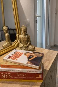 a stack of books sitting on a table with a statue at appartamento Pekoe in Modena