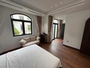 a bedroom with a bed and a couch and a window at MoonLight Homestay in Hòa Bình
