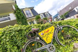 a bike parked next to a hedge with a sign on it at Doppelzimmer mit direktem Moselblick in Briedern