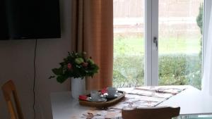 a dining room table with a vase of flowers on it at Doppelzimmer mit direktem Moselblick in Briedern