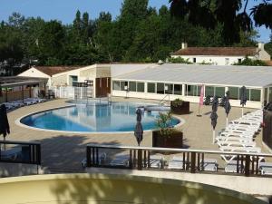 a large swimming pool with chairs and a building at Mobil home in Angles