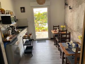 a kitchen with a table and two tables and a window at La Note Bleue - Chambres d'hôtes in Échillais
