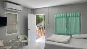 a bedroom with a bed and a table and chairs at Similan Resort & Water Fall in Ban Lam Ru (1)