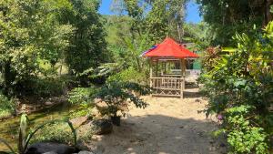 a gazebo with a red roof in a garden at Similan Resort & Water Fall in Ban Lam Ru (1)