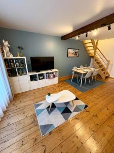 ein Wohnzimmer mit einem Tisch und einem Fernseher in der Unterkunft O'Balcon in Sainghin-en-Mélantois