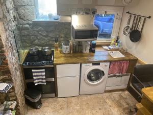 a small kitchen with a washing machine and a washer at Crows Nest - cosy, tiny cottage in Castletown
