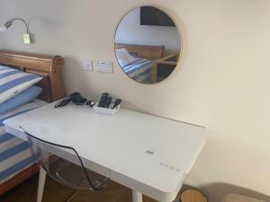 a white table in a bedroom with a mirror at Crows Nest - cosy, tiny cottage in Castletown