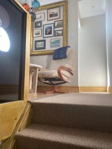 a living room with a chair and a television at Crows Nest - cosy, tiny cottage in Castletown