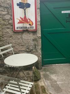 a white table and a chair next to a door at Crows Nest - cosy, tiny cottage in Castletown