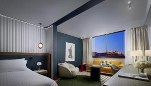 a hotel room with a bed and a chair at InterContinental Athenaeum Athens by IHG in Athens +89 photos