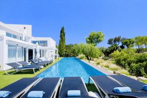 a swimming pool with chaise lounge chairs and a villa at CASA DO LAGO, Infinity Pool, Mountains & Sea view in Estói