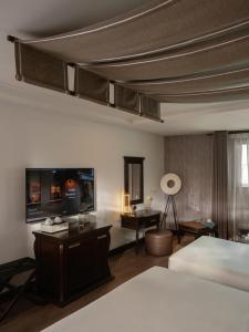 a hotel room with a bed and a desk and a room at The Odys Boutique Hotel in Ho Chi Minh City +116 photos