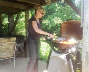 a woman preparing a bbq on a grill at Picturesque School House Retreat in Meaford +23 photos