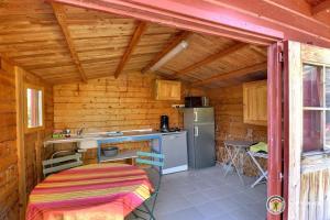 a kitchen with a stove and a refrigerator in a cabin at mondonlehaut in Saint-Fortunat-sur-Eyrieux