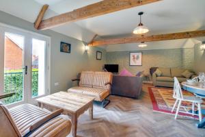 a living room with a couch and a table at Snettisham Watermill Pet Friendly Historic Listed Property in Snettisham
