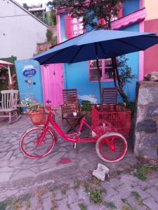 a red bike is parked under an umbrella at AKİDE BUTİK PANSİYON in Mudanya