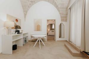 a living room with a white table and a room at Corte Vespro in Ugento