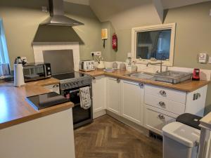 a kitchen with a stove top oven next to a sink at Snettisham Watermill Pet Friendly Historic Listed Property in Snettisham +14 photos