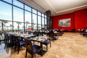 a dining room with tables and chairs and large windows at Porto Said Hotel & Spa in Port Said
