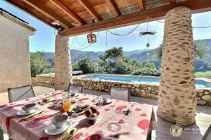 a table with food on it with a view of a pool at mondonlehaut in Saint-Fortunat-sur-Eyrieux