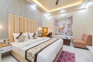 a bedroom with a large bed and a chair at INDRA PALACE Unit 2 in Jaipur