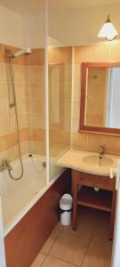 a bathroom with a sink and a tub and a mirror at Maison, proche parking, piscine chauffée, en résidence, 4 ou 5 pers, RDC, lac, nature et pêche in Monflanquin