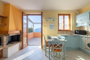 a kitchen with a table and a balcony at Hostdomus - Villa Bea free garage and pool in Magliolo