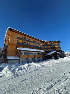 a building in the snow with footprints in the snow at Crystal Hôtel in Courchevel
