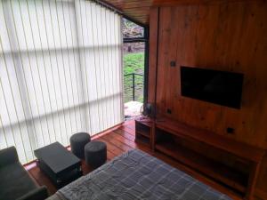 a bedroom with a bed and a flat screen tv at Pineforrest in Sukapura