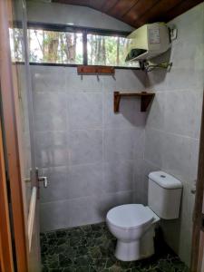a bathroom with a toilet and a window at Pineforrest in Sukapura