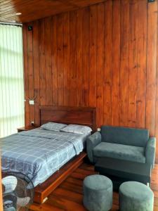 a bedroom with a bed and a couch and a chair at Pineforrest in Sukapura