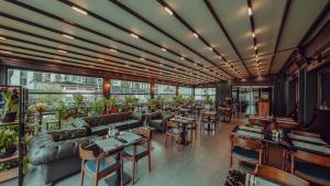 a restaurant with couches and tables and windows at Grand Makel Hotel Topkapi in Istanbul