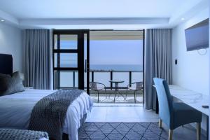 a hotel room with a bed and a view of the ocean at Mossel-Bay Waterfront Accommodation in Mossel Bay