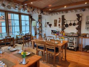 a kitchen and dining room with wooden tables and chairs at Gästehaus Ermen in Kamp-Lintfort