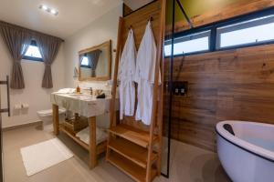 a bathroom with a shower and a sink and a tub at Ananaí Chalés Exclusivo para Casais in Pomerode +32 photos