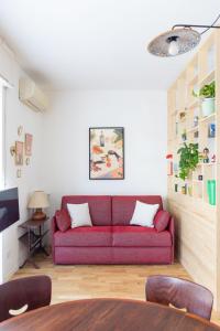 a living room with a red couch in a room at Bindarella ai Navigli in Milan +6 photos