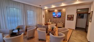 a waiting room with chairs and tables and a tv at Del Monte Predeal in Predeal